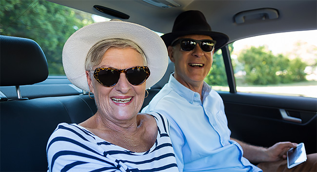 Older couple in back seat of sedan